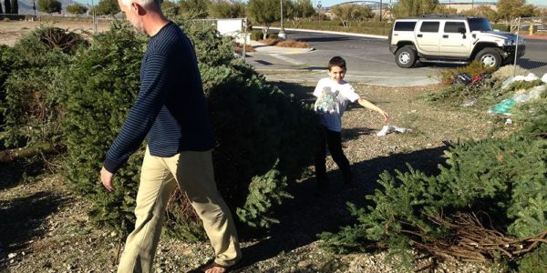 Father and son recycling a Christmas tree in Summerlin