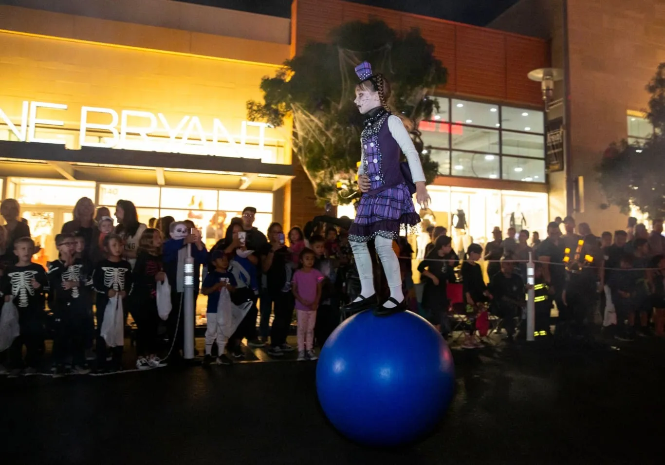 Girl balancing on ball in the Parade of Mischief at Downtown Summerlin