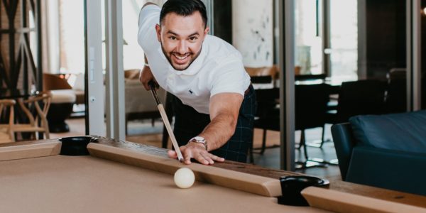 Young man playing pool at Tanager Luxury Apartments in Downtown Summerlin