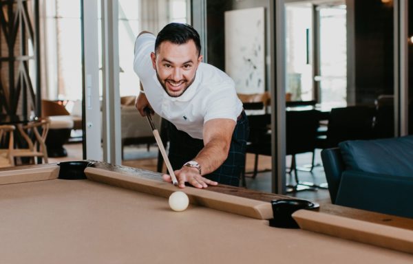 Young man playing pool at Tanager Luxury Apartments in Downtown Summerlin