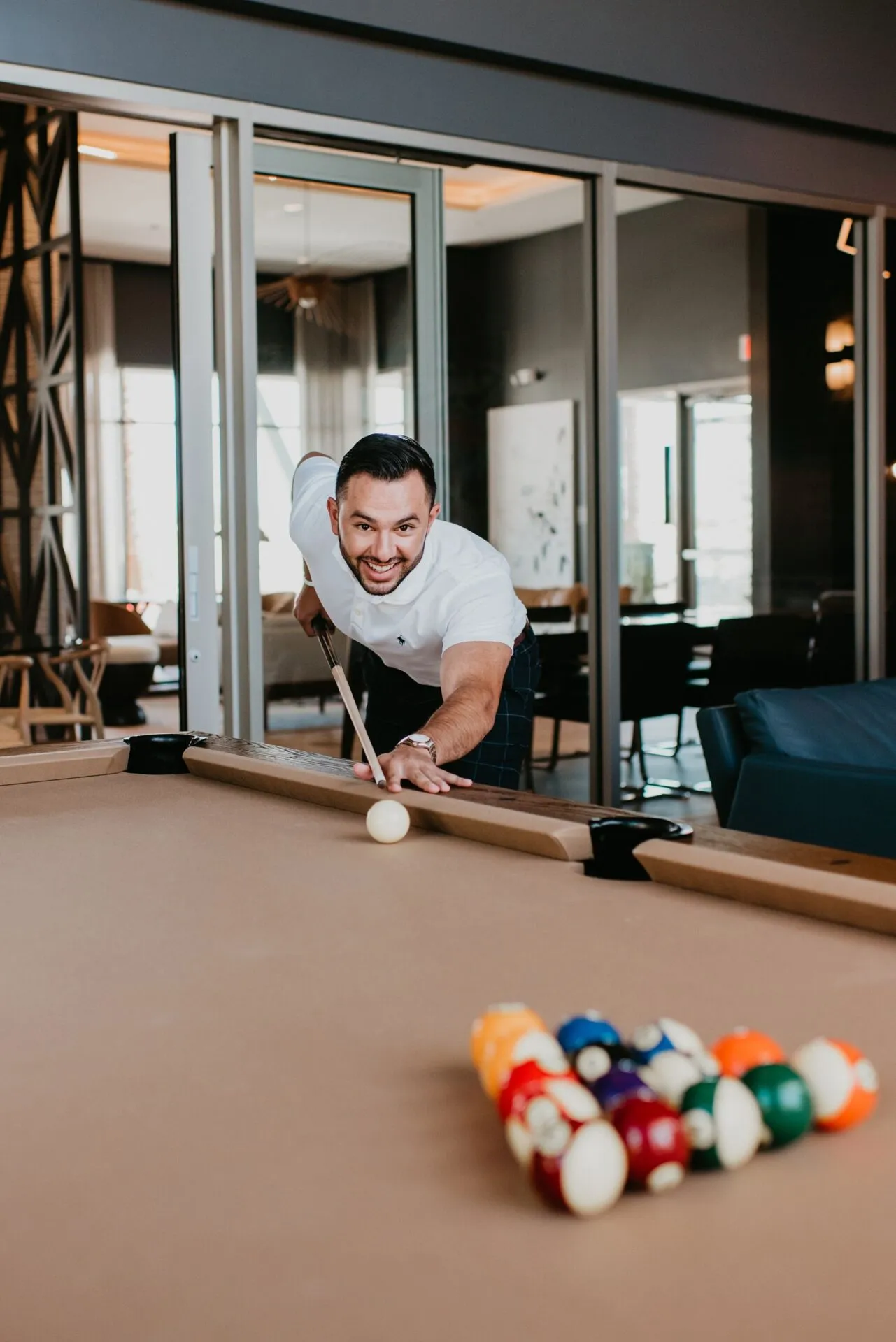 Young man playing pool at Tanager Luxury Apartments in Downtown Summerlin