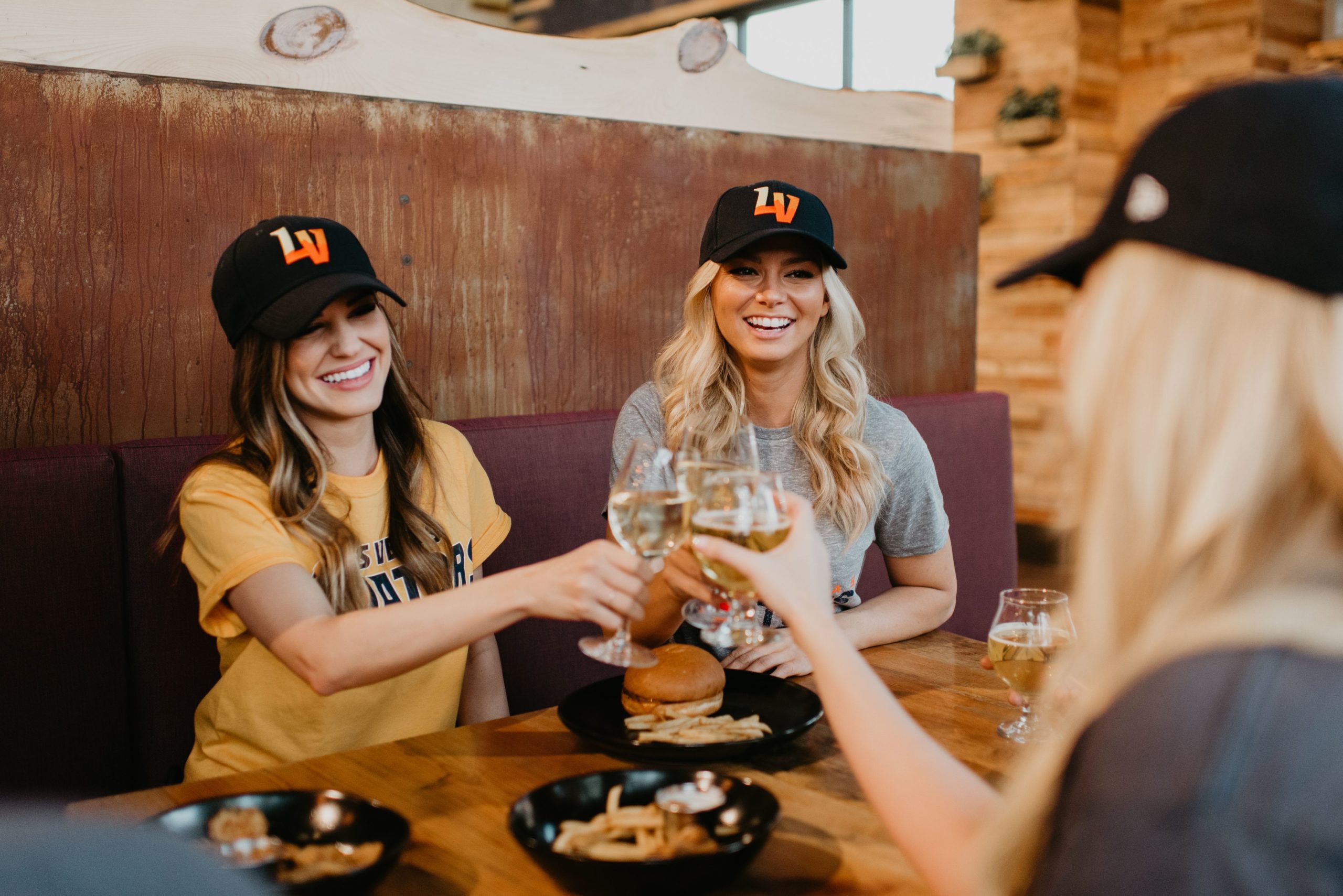 Three girls in Aviators gear raising beer glasses