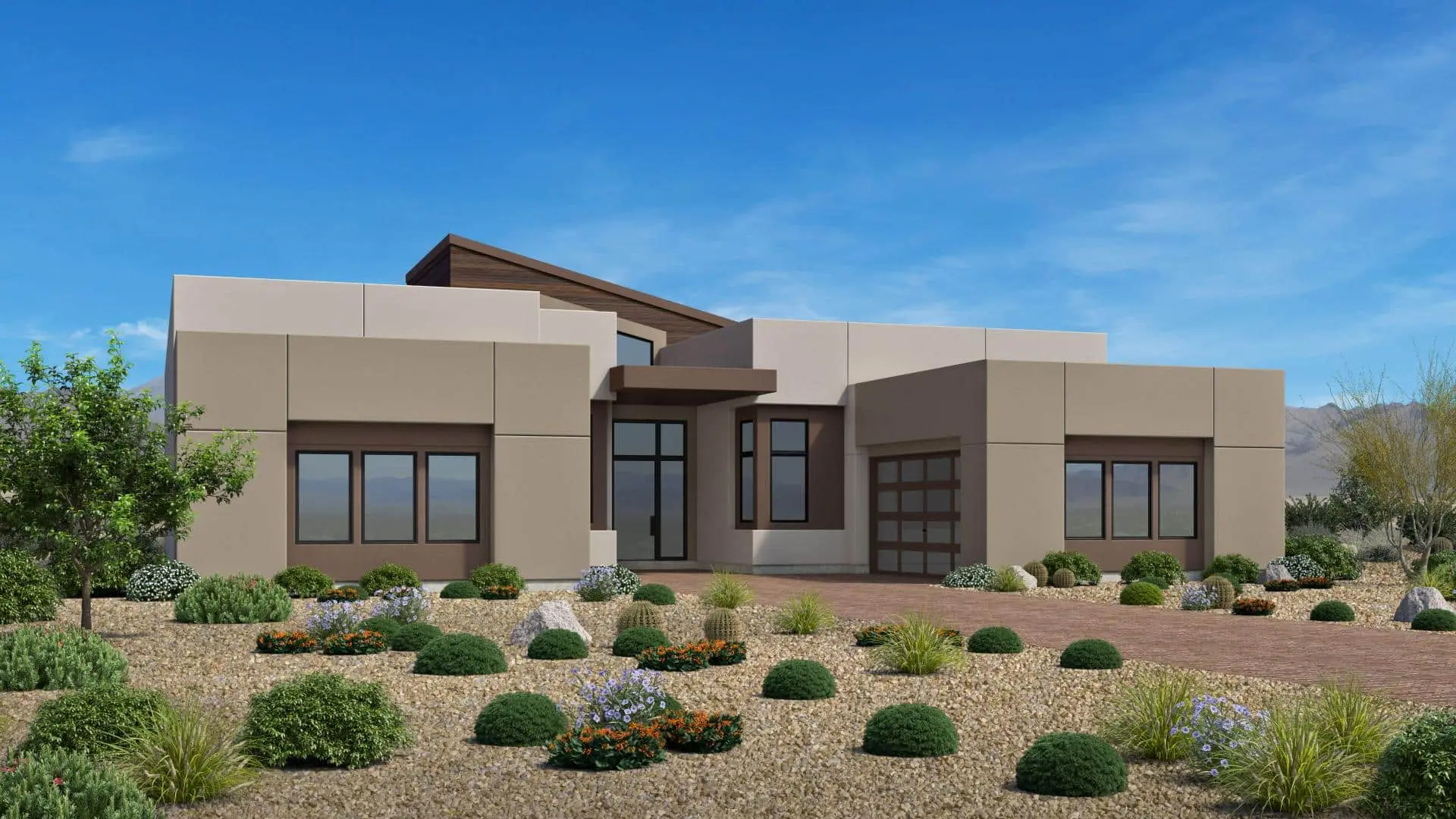 Modern single-story house with flat roofs and large windows, surrounded by a desert landscape with rocks, gravel, and various small shrubs and plants under a clear blue sky.