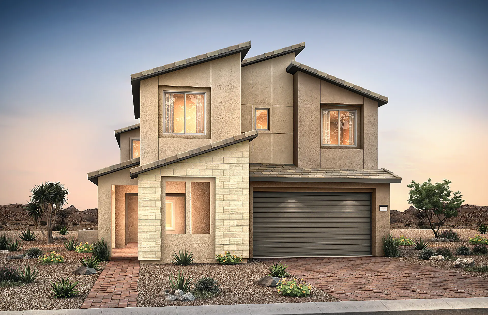 3536-7-Tivoli-C9 Modern two-story house with angular rooflines, large windows, and a two-car garage. Located in Tivoli at Brantley by Pulte Homes, the beige stucco and stone exterior is surrounded by desert landscaping with rocks, shrubs, and small trees at dusk.