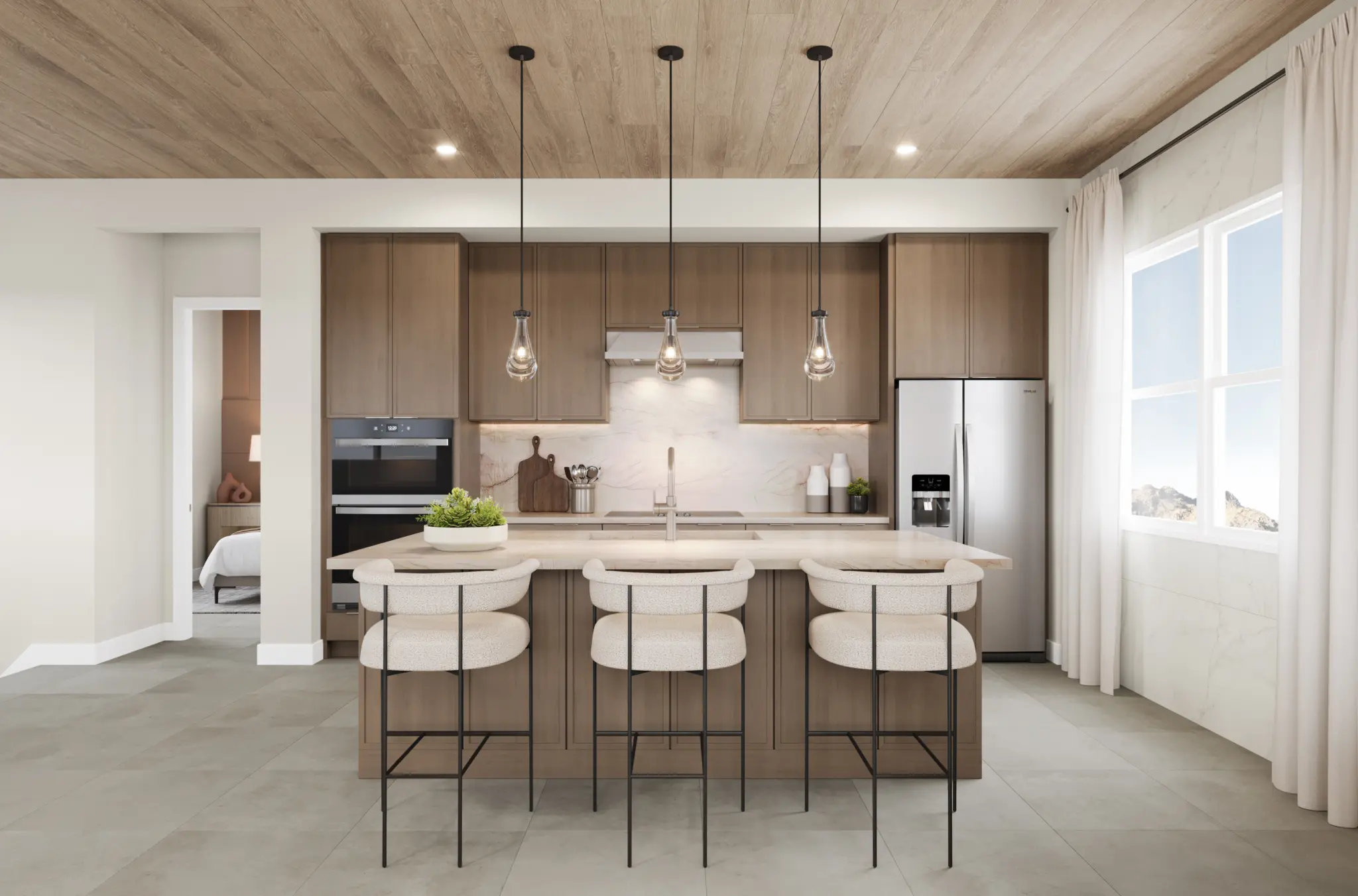 9048_NV-LV_FITZROY_CON_KITCHEN_1-2048×1352 Modern kitchen in the Fitzroy Floorplan at The Loughton by Toll Brothers, featuring wood cabinets, an island with three cushioned stools, pendant lights, stainless steel appliances, and a window filling the warm space with natural light.