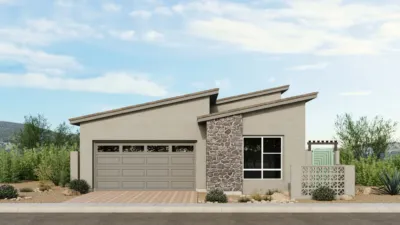 Modern single-story house with two slanted roofs, a double garage, stone accent wall, large front window, and a small fenced patio. Surrounded by desert landscaping and set against a backdrop of greenery and hills.