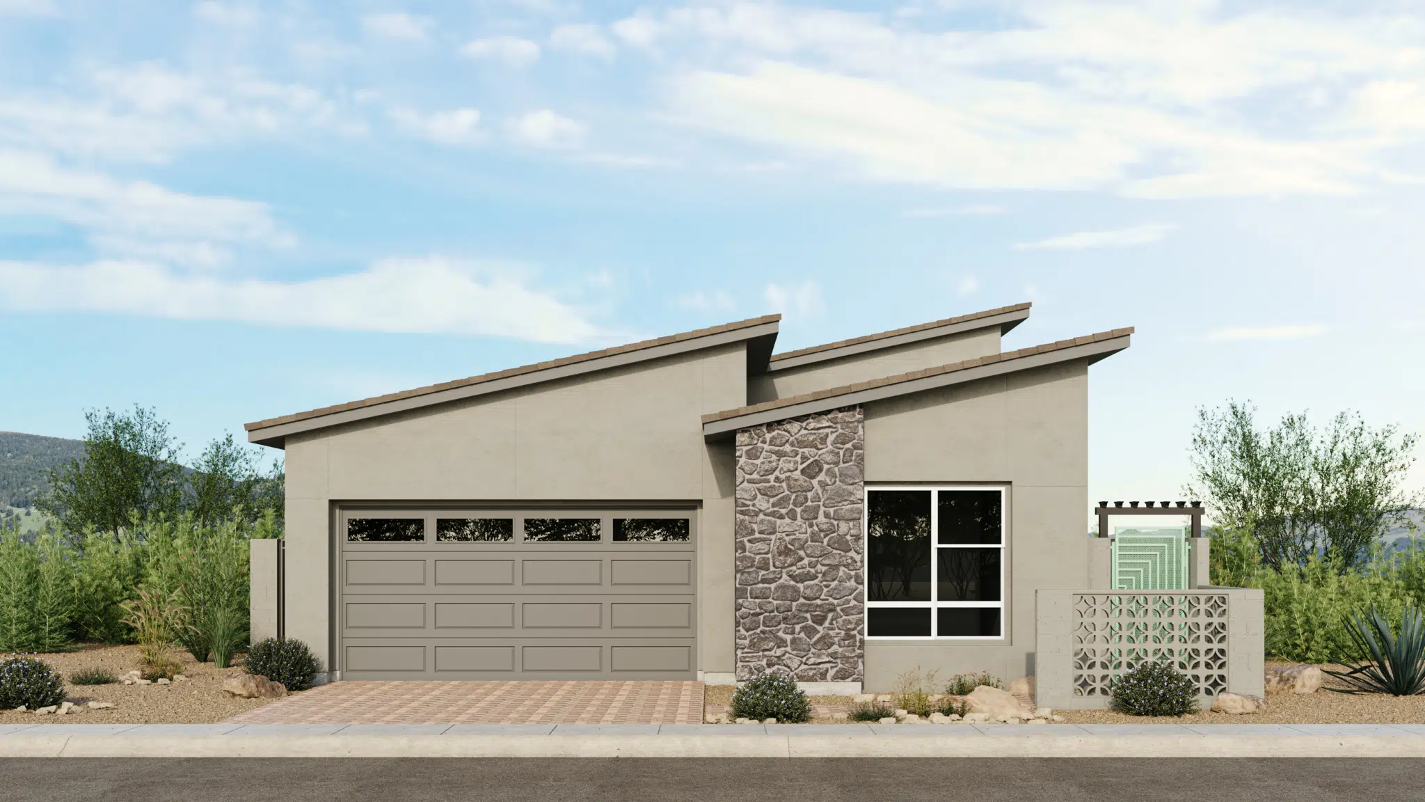 Modern single-story house with two slanted roofs, a double garage, stone accent wall, large front window, and a small fenced patio. Surrounded by desert landscaping and set against a backdrop of greenery and hills.