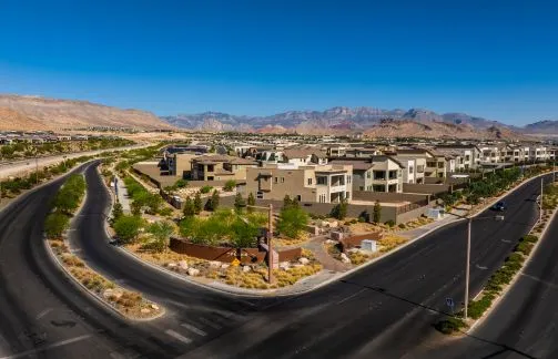 Illustration of a landscaped entry monument for a residential community called Peaks in Summerlin, featuring pathways, desert plants, walls, and people walking near a road with mountains in the background.
