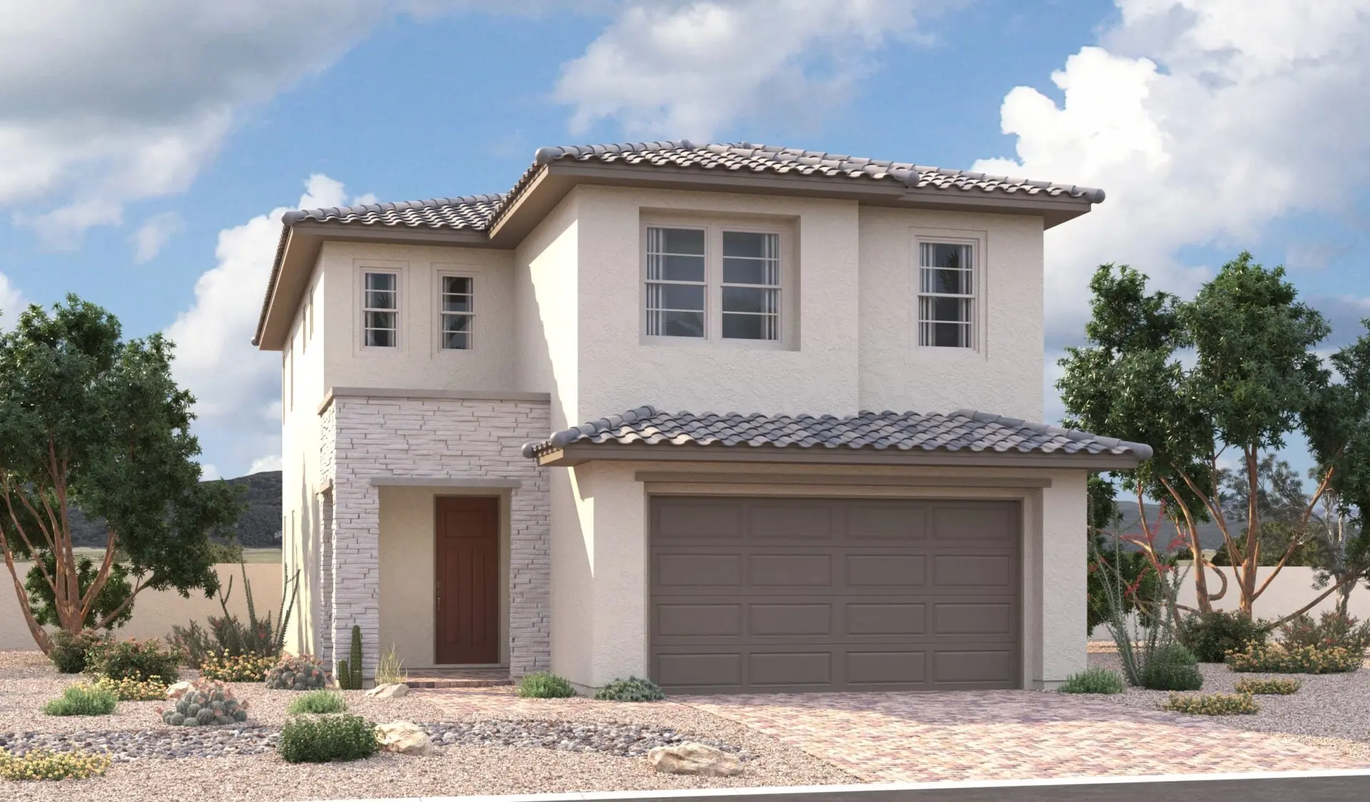Two-story modern house with light-colored stucco and stone exterior, tiled roof, double garage, and a small front yard landscaped with rocks, desert plants, and trees under a partly cloudy sky.