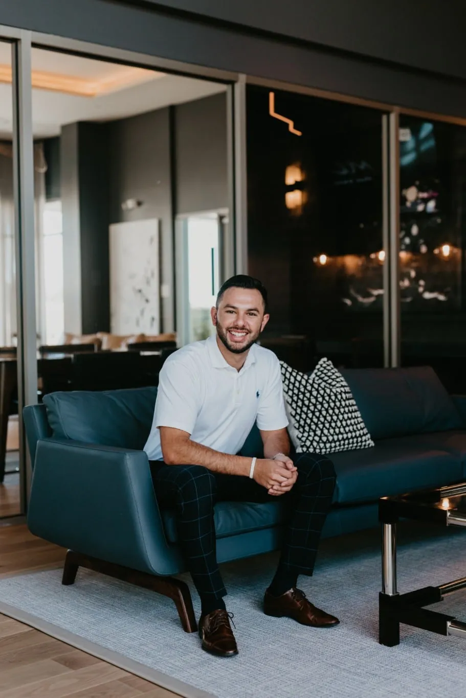 Young man on couch at Tanager Luxury Apartments in Downtown Summerlin