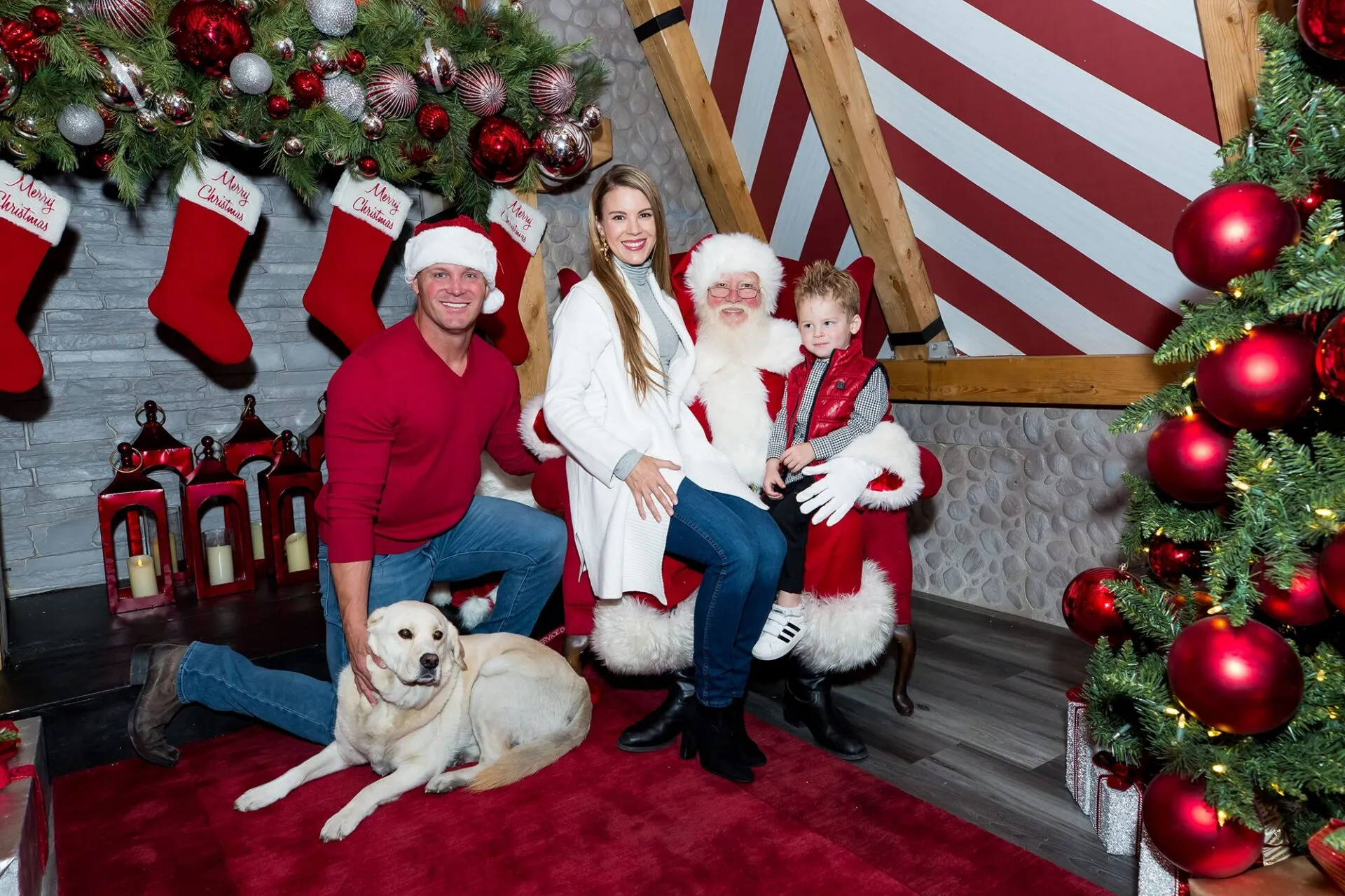 Family of three with a dog posing for a picture with Santa at Downtown Summerlin